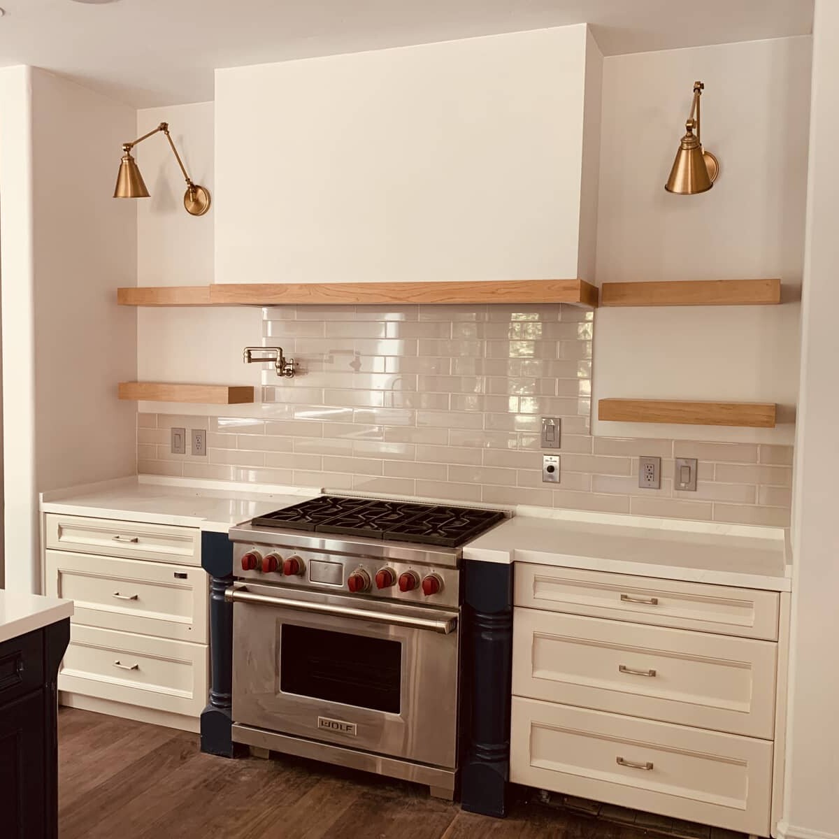 Kitchen with white cabinets, gold-colored lamps and oven
