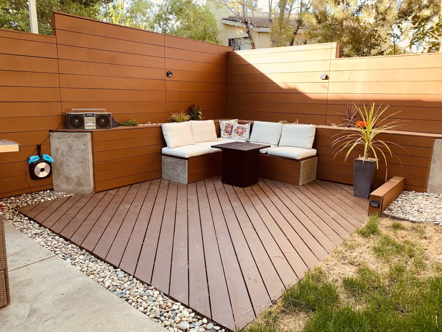 Sunny backyard with dry lawn and seating