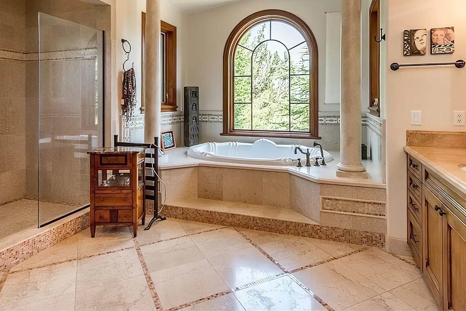beige bathroom with shower and bathtub with large arched window